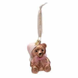 Bruine glazen beer met roze slaapmuts en strik aan lint met Baby's First Christmas